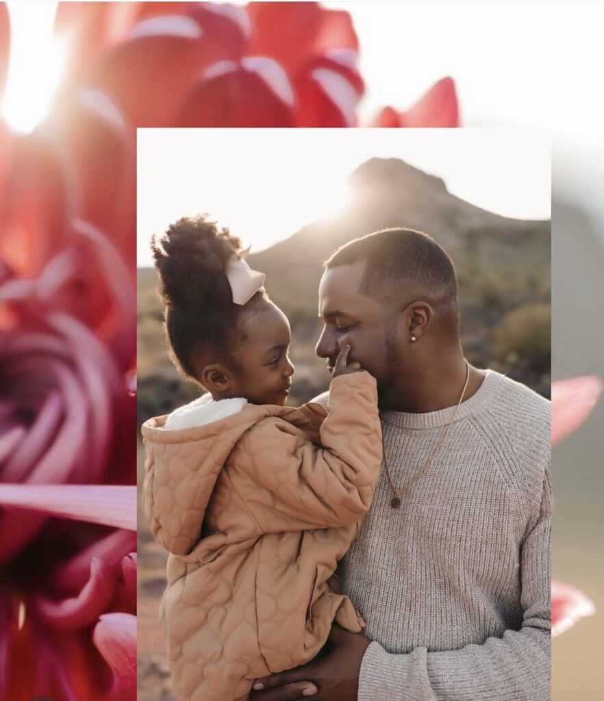 A father holding his daughter as she embraces him, with one hand gently resting on his cheek, showcasing love and connection.