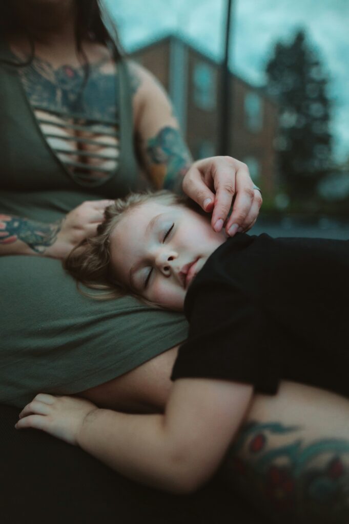 Mother consoling daughter as she rests her head in her lap, showing a moment of emotional connection and comfort.